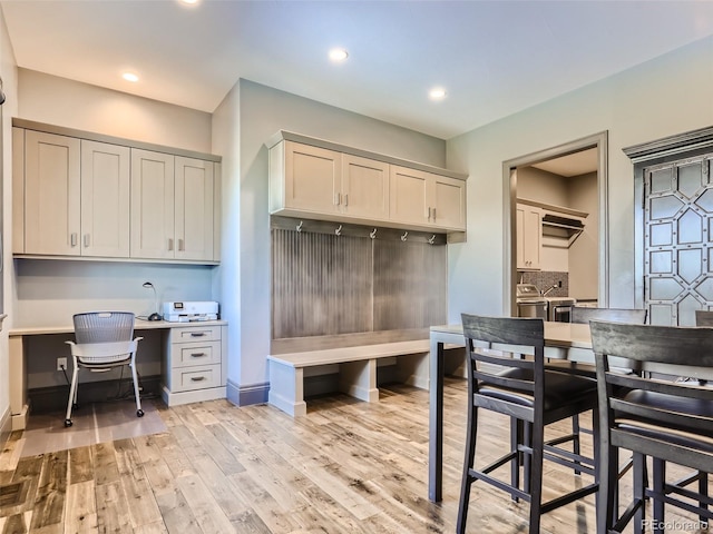 mudroom featuring light hardwood / wood-style flooring and built in desk