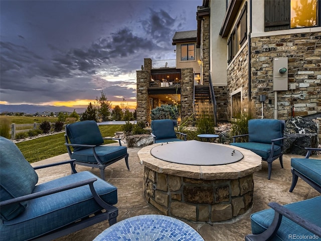 patio terrace at dusk featuring an outdoor fire pit