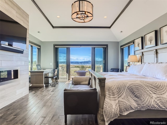 bedroom featuring wood-type flooring, vaulted ceiling, access to outside, ornamental molding, and a fireplace