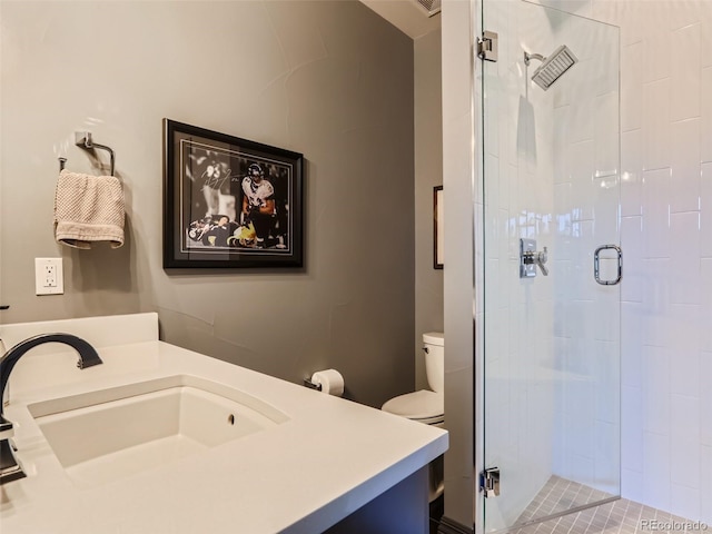 bathroom with vanity, toilet, and a shower with shower door