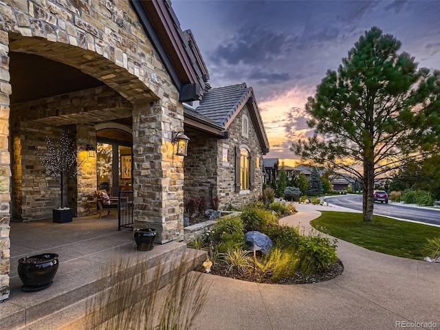 property exterior at dusk featuring a patio area