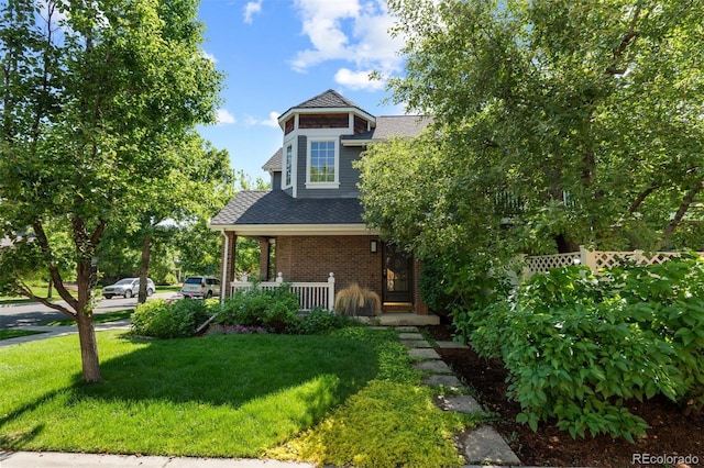 7746 E Severn Pl, Denver, CO 80230 - view of front of home with a porch, a front yard, brick siding, and roof with shingles