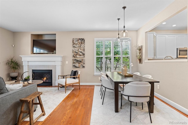 7746 E Severn Pl, Denver, CO 80230 - dining room with light wood-style flooring, a fireplace, and recessed lighting