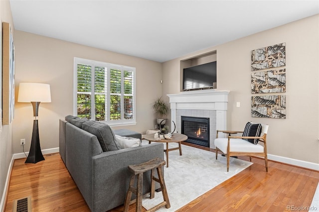 7746 E Severn Pl, Denver, CO 80230 - living area featuring a tiled fireplace and light wood-type flooring