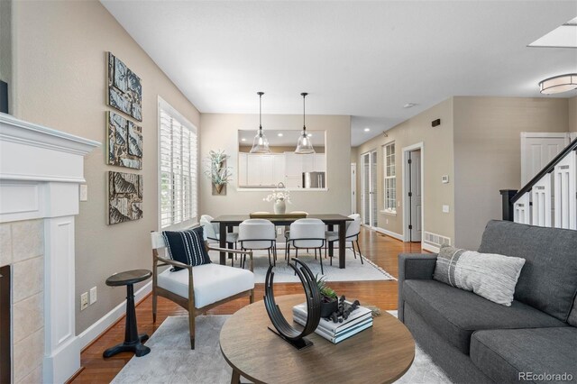 7746 E Severn Pl, Denver, CO 80230 - living area featuring wood finished floors, stairway, a fireplace, and recessed lighting