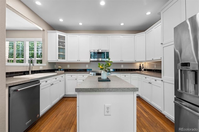 7746 E Severn Pl, Denver, CO 80230 - kitchen with appliances with stainless steel finishes, hardwood / wood-style flooring, white cabinetry, a center island, and recessed lighting