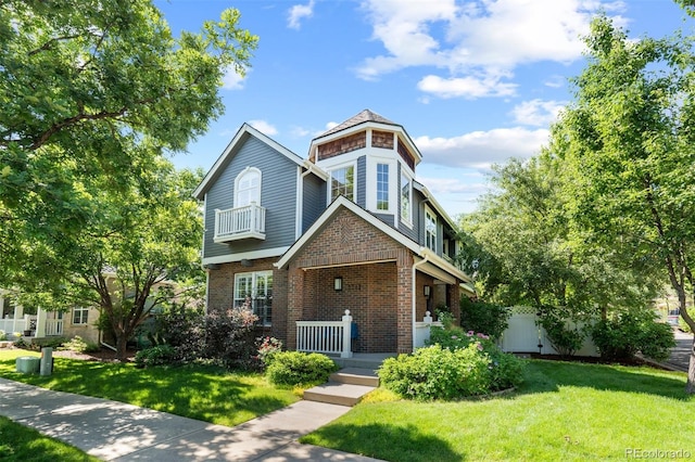 7746 E Severn Pl, Denver, CO 80230 - view of front facade featuring covered porch, brick siding, and a front lawn