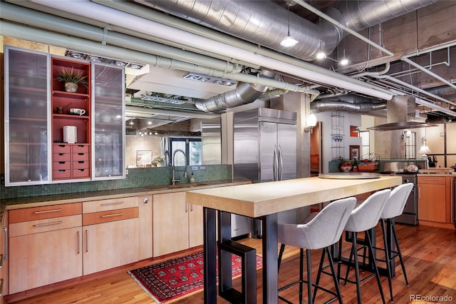 2000 Little Raven St Unit 1B, Denver, CO 80202 - kitchen featuring a sink, light wood-type flooring, stainless steel range oven, and light brown cabinetry