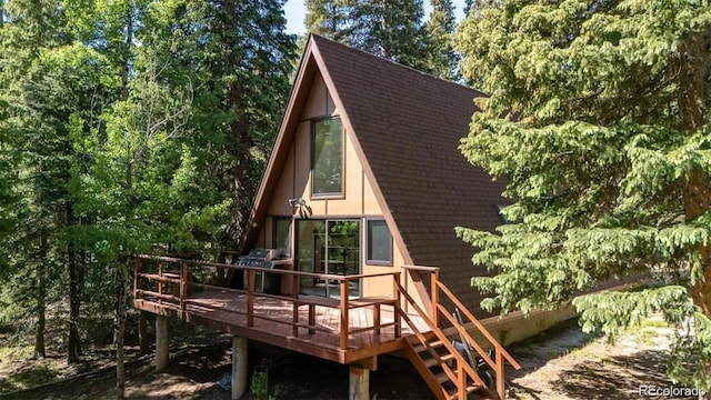 100 Aspen Ln, Evergreen, CO 80439 - rear view of house featuring a wooden deck and roof with shingles