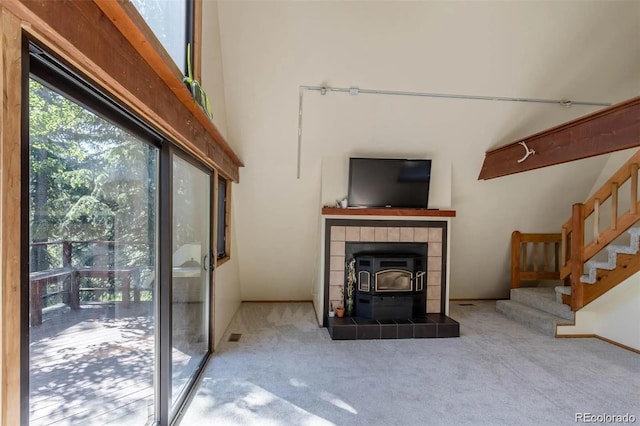 100 Aspen Ln, Evergreen, CO 80439 - carpeted living room featuring stairs, a wood stove, and a towering ceiling