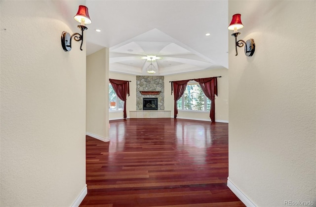 unfurnished living room with recessed lighting, a fireplace, baseboards, and wood finished floors