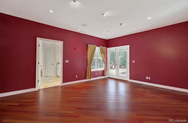 unfurnished room featuring french doors, baseboards, and wood finished floors