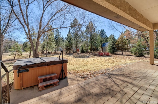 deck featuring a hot tub and fence