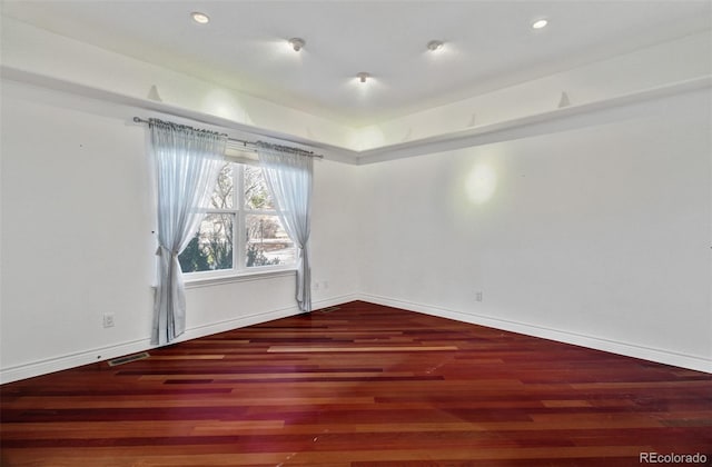 empty room with recessed lighting, visible vents, baseboards, and wood finished floors