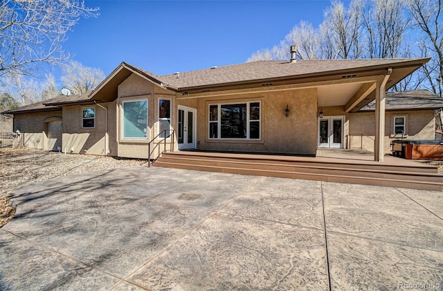 back of property with french doors, a wooden deck, and stucco siding