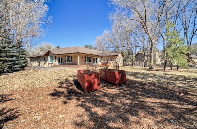 back of property featuring stucco siding