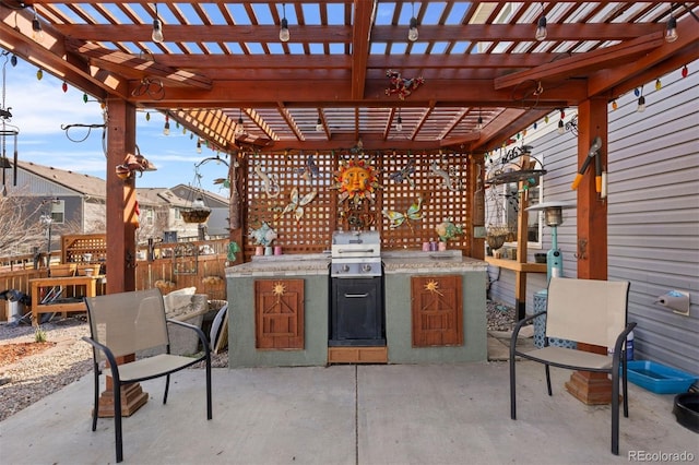 view of patio with fence, a pergola, a grill, and exterior kitchen