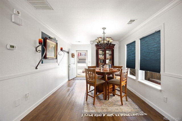 dining space featuring visible vents, ornamental molding, wood finished floors, and a notable chandelier