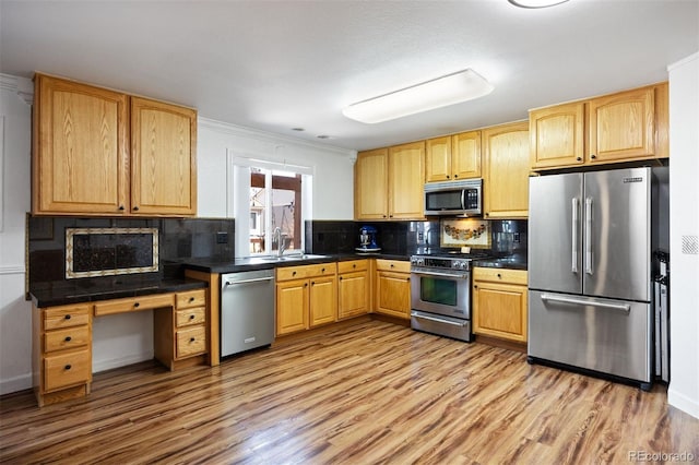 kitchen featuring decorative backsplash, light wood finished floors, and stainless steel appliances