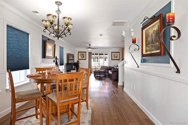 dining area featuring visible vents, ornamental molding, dark wood-style flooring, baseboards, and ceiling fan with notable chandelier