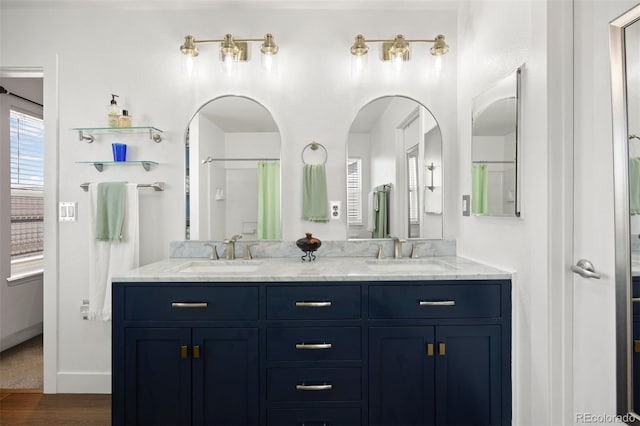 bathroom with double vanity, a sink, and wood finished floors