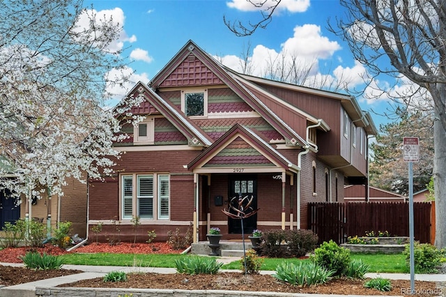 victorian-style house with fence and brick siding