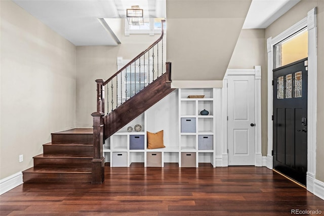foyer with wood finished floors, stairway, and baseboards