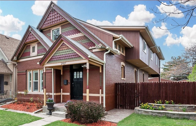 victorian house with fence and brick siding