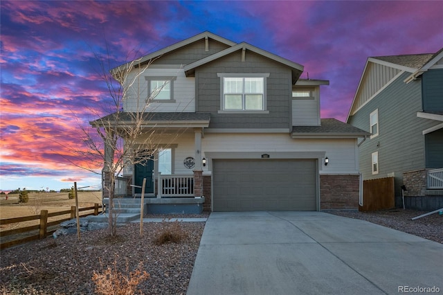 craftsman inspired home featuring covered porch, concrete driveway, an attached garage, and fence