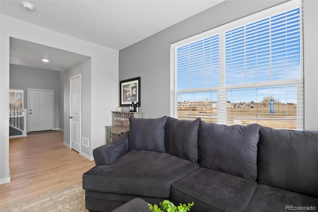 living area with visible vents, baseboards, and wood finished floors