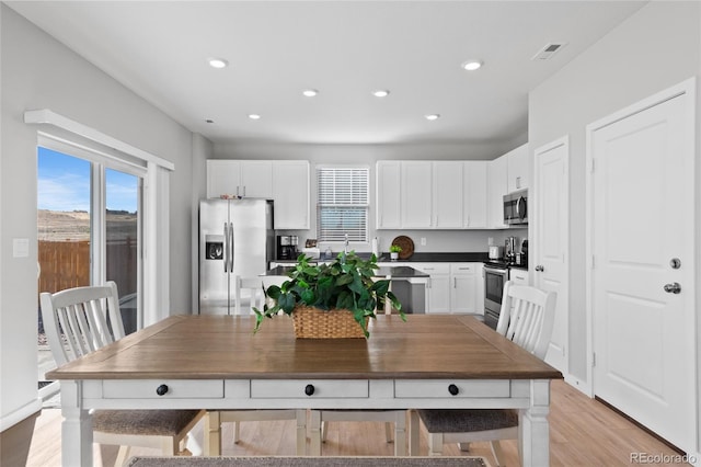 kitchen featuring visible vents, light wood finished floors, recessed lighting, stainless steel appliances, and white cabinets