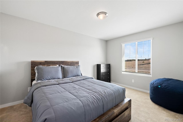 bedroom with light carpet and baseboards