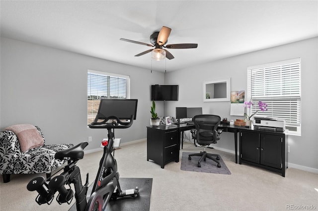 office space featuring light carpet, baseboards, and a ceiling fan