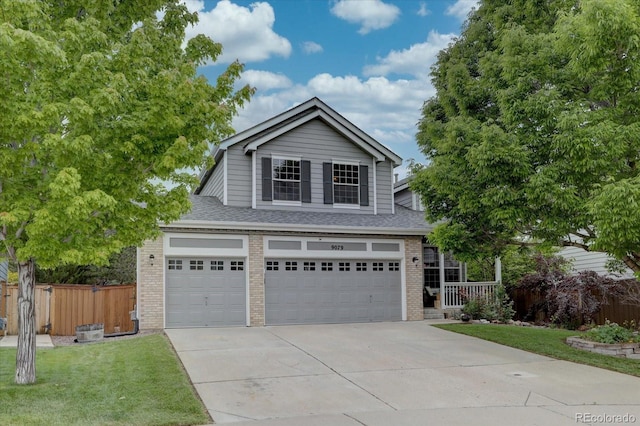 9079 Garnet St, Highlands Ranch, CO 80126 - view of front of property with brick siding, driveway, a shingled roof, and an attached garage