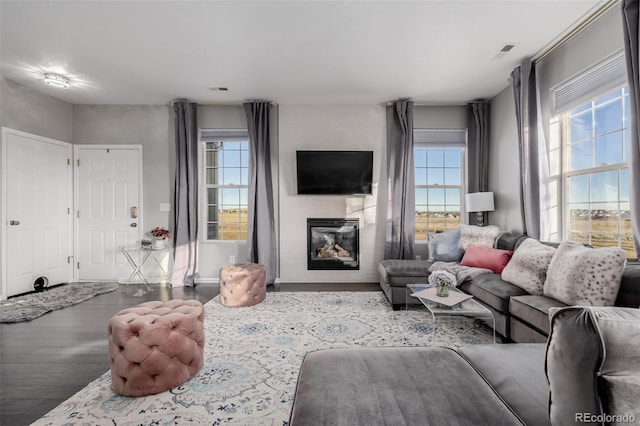 living room featuring light wood-type flooring and a large fireplace