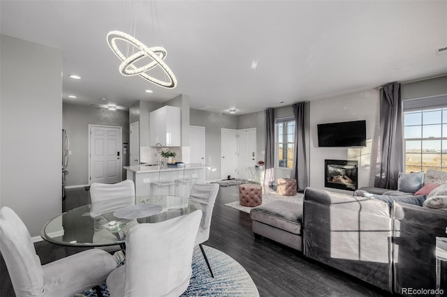 dining space featuring plenty of natural light, dark hardwood / wood-style flooring, a fireplace, and a chandelier