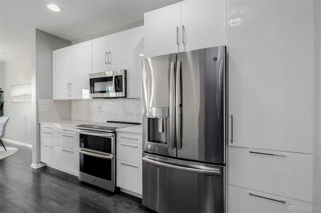 kitchen with white cabinets, appliances with stainless steel finishes, dark hardwood / wood-style flooring, and tasteful backsplash