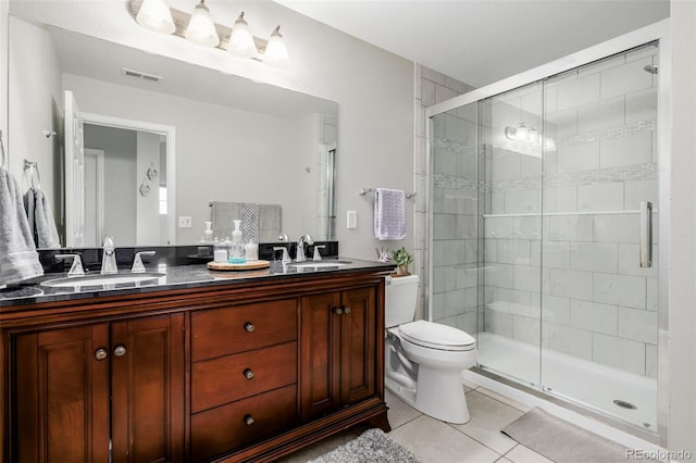 bathroom featuring tile patterned flooring, vanity, toilet, and walk in shower