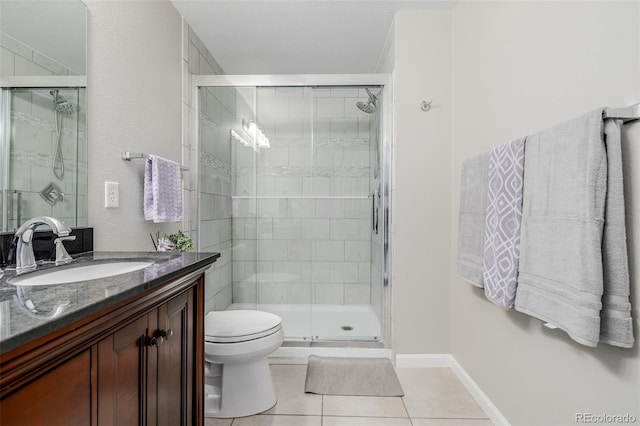 bathroom featuring tile patterned flooring, vanity, toilet, and an enclosed shower