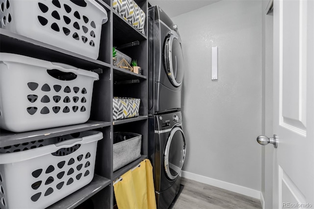 washroom featuring hardwood / wood-style floors and stacked washer / dryer