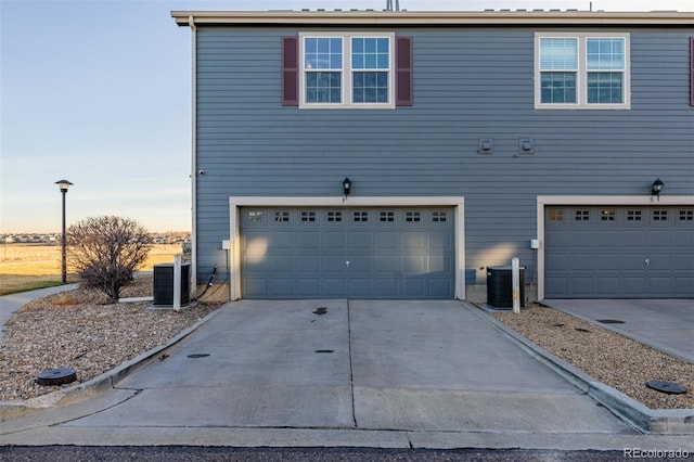 view of front facade featuring a garage and central air condition unit