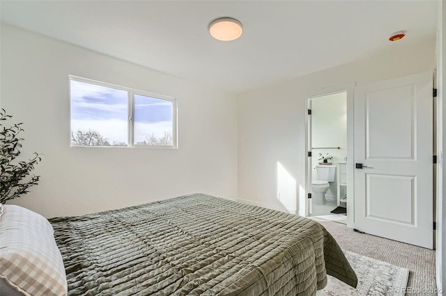 bedroom featuring connected bathroom and carpet