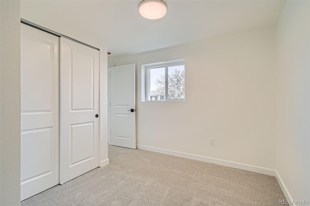 unfurnished bedroom with light carpet and a closet