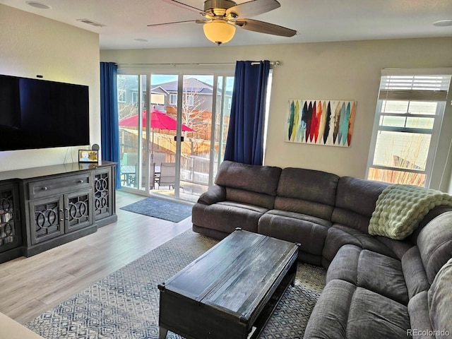 living area featuring visible vents, wood finished floors, and a ceiling fan