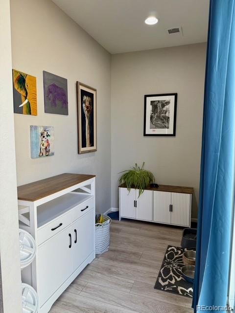 interior space with visible vents, radiator, and light wood-style flooring