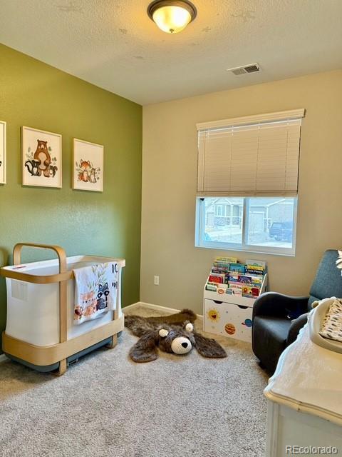 game room with visible vents, carpet floors, and a textured ceiling