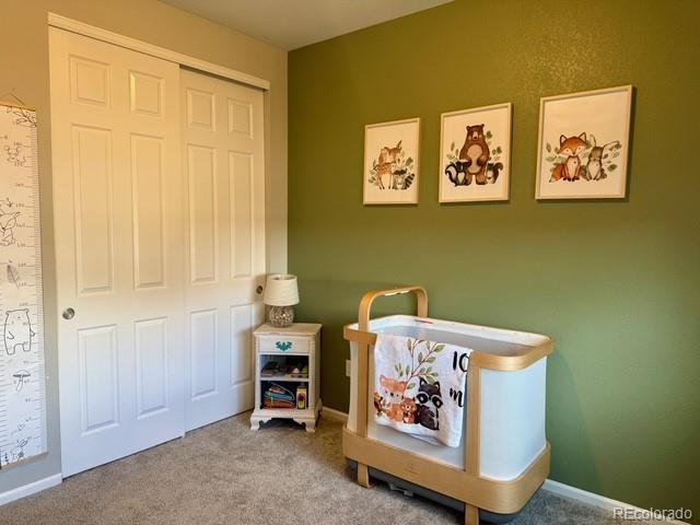 carpeted bedroom featuring baseboards and a closet