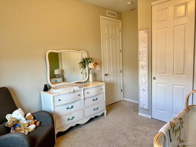 bedroom featuring visible vents, light colored carpet, and baseboards