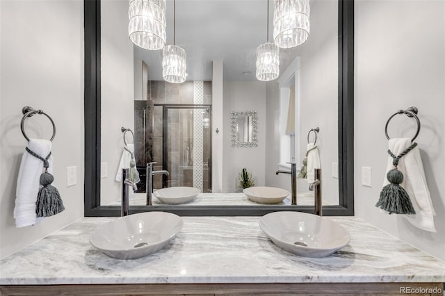 bathroom with a shower with shower door and vanity