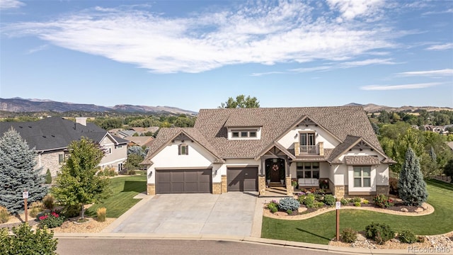 view of front of house featuring a garage, a mountain view, and a front yard